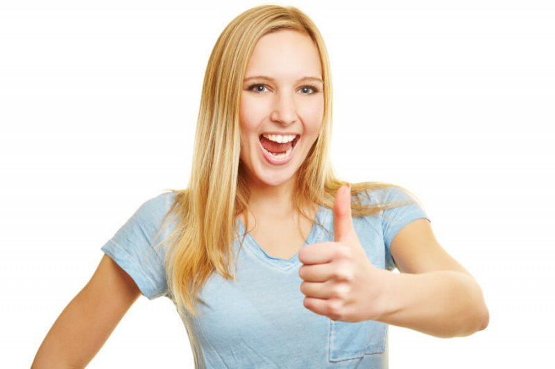 Frau zeigt Vorteile der Zahnersatzversicherung
